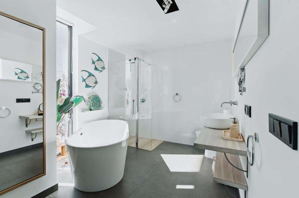 View of one of the bathrooms in the house, spacious, with bathtub, shower, handcrafted decorations and bathroom furniture - Villa Horizont Dreams