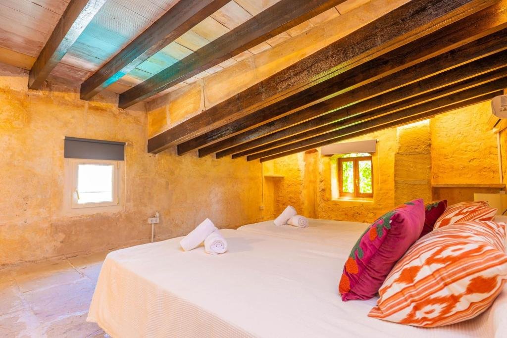 View of an exotic room on the second floor of the house, with a wooden ceiling, large bed, handcrafted windows overlooking the garden - Villa Spring