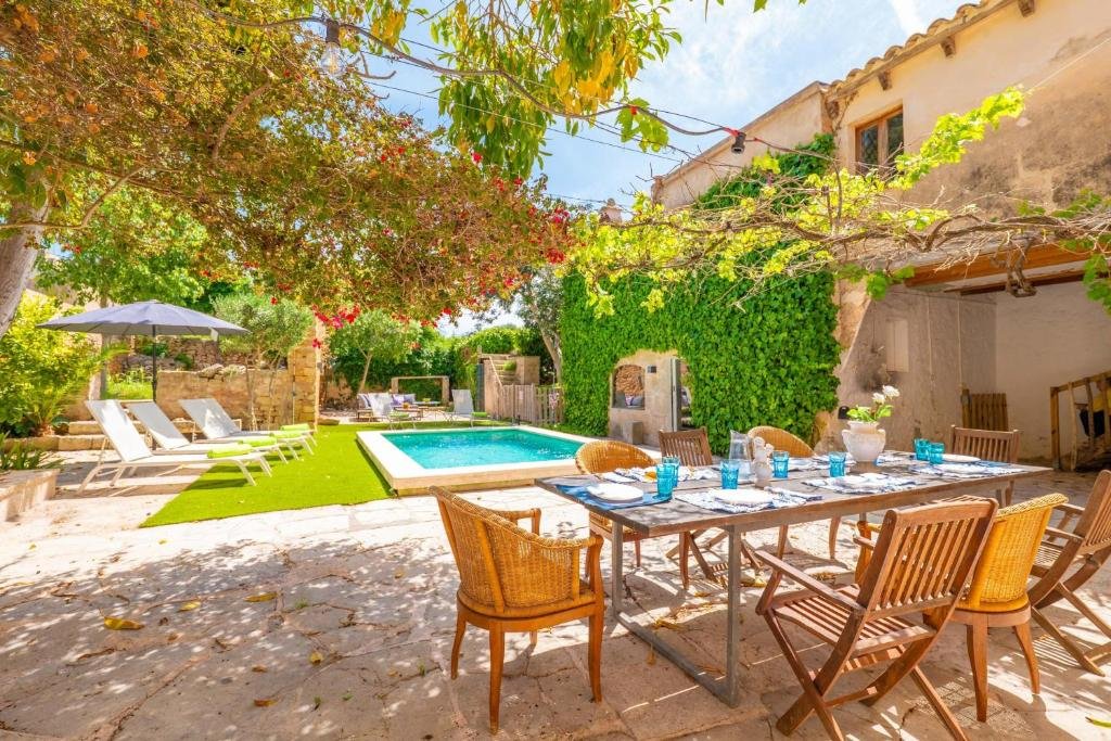 View of the villa's spring garden, its lounge chairs and handcrafted tables, swimming pool and side architecture of the house - Villa Spring